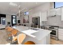 Spacious kitchen featuring a large island, stainless steel appliances, ample counter space, and bar stool seating at 2442 Champa St, Denver, CO 80205