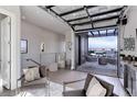 Stylish indoor/outdoor living room with comfortable seating and a glass garage door leading to a deck with city views at 2442 Champa St, Denver, CO 80205
