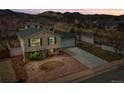 Aerial view of a home with a two-car garage, landscaped yard, and mountain views in the background at 4309 S Coors Ct, Morrison, CO 80465