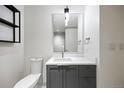 Modern bathroom with a gray vanity, white countertops, and a tiled wall mirror at 1750 Wewatta St # 1536, Denver, CO 80202