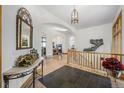Bright foyer with gleaming hardwood floors, stone tiled entry, arched doorways, and staircase at 10985 Ambush Rock, Littleton, CO 80125