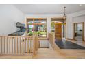 Bright foyer with gleaming hardwood floors, stone tiled entry, staircase, and windows at 10985 Ambush Rock, Littleton, CO 80125