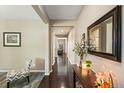 Inviting hallway with dark wood floors, neutral walls, and decorative accents at 15352 E 117Th Ave, Commerce City, CO 80022