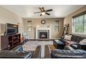 Cozy living room with a stone fireplace, plush seating, and abundant natural light at 15352 E 117Th Ave, Commerce City, CO 80022