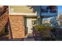 A sunny front entrance features brick accents and a white door for a charming welcome at 919 S Dawson Way # 7, Aurora, CO 80012