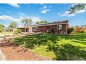 Charming brick home featuring a large front yard with mature trees at 5593 E Center Ave, Denver, CO 80246