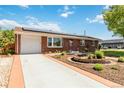 Charming brick home featuring a driveway and beautifully landscaped front yard at 5593 E Center Ave, Denver, CO 80246