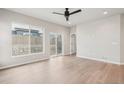 Spacious living room with light wood floors, a ceiling fan, and a sliding glass door to access the backyard at 17673 Brass Buckle Way, Monument, CO 80132