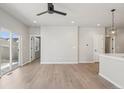 Open-concept living room with light wood floors, neutral walls, modern lighting, and access to the backyard at 17673 Brass Buckle Way, Monument, CO 80132