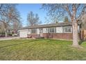 Inviting single-story home with a well-kept lawn, brick accents, and an attached garage on a sunny day at 2904 S Idalia St, Aurora, CO 80013