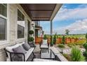 Relaxing covered front porch with outdoor seating and a view of the landscaped yard at 14998 Cast Pebble Cir, Parker, CO 80134