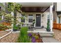 Inviting front porch with comfortable seating and lush landscaping and neutral exterior at 14998 Cast Pebble Cir, Parker, CO 80134