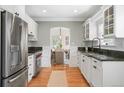 Modern kitchen featuring stainless steel appliances, white cabinetry, and hardwood floors at 1767 S Sherman St, Denver, CO 80210