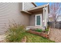 A welcoming, covered entrance with stylish siding, a small garden, and a well-manicured lawn at 6774 St Vrain Ranch Blvd, Firestone, CO 80504