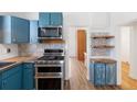 Charming kitchen with blue cabinets, stainless steel appliances, and stylish backsplash at 1103 Lipan St, Denver, CO 80204