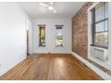 Bright living room features hardwood floors, exposed brick accent wall, and abundant natural light at 1103 Lipan St, Denver, CO 80204