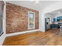 Inviting living room featuring a brick wall, hardwood floors, and an open layout at 1103 Lipan St, Denver, CO 80204