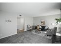 Cozy living room with plush carpet, comfortable seating, and neutral decor at 3855 S Monaco St # 208, Denver, CO 80237