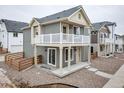 Two-story home with white balcony, gray siding, and gravel landscaping at 13615 E 103Rd Ave, Commerce City, CO 80022