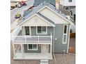 Exterior elevation of gray two-story home featuring a charming second story balcony at 13615 E 103Rd Ave, Commerce City, CO 80022