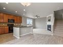 Open-concept kitchen and living area, featuring a granite island and cozy fireplace at 3672 S Perth Cir # 101, Aurora, CO 80013