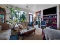 Cozy living room with a fireplace, indoor plants and TV at 10487 W Hampden Ave # 101, Lakewood, CO 80227