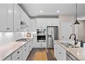 Bright kitchen featuring white cabinetry, stainless steel appliances, granite countertops, and modern fixtures at 4475 Hidden Gulch Rd, Castle Rock, CO 80104
