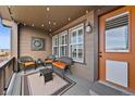 Relaxing outdoor porch with wicker seating, decorative metal artwork, string lights, and views of the surroundings at 4475 Hidden Gulch Rd, Castle Rock, CO 80104