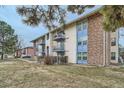 Exterior view of multi-Gathering unit with balconies, brick accents, and winter landscaping at 12174 Melody Dr # 203, Westminster, CO 80234