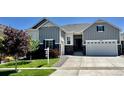 Charming two-story home featuring manicured lawn, gray siding, and a two-car garage, and professional landscaping at 9028 S Catawba St, Aurora, CO 80016