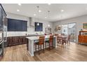 Modern kitchen with a large island, stainless steel range hood and appliances, and dark cabinets at 9028 S Catawba St, Aurora, CO 80016