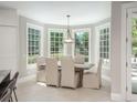 Bright dining room with large windows, elegant chandelier, and seating for six at 18 Foxtail Cir, Englewood, CO 80113