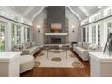Bright living room featuring a vaulted ceiling, stone fireplace, large windows, and hardwood floors at 18 Foxtail Cir, Englewood, CO 80113
