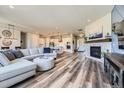 Spacious open layout with fireplace, hardwood floors, views into the kitchen and a large sectional sofa at 3344 Carabiner St, Castle Rock, CO 80108