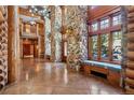 Spacious foyer featuring stone pillars, a window bench, and exquisite log beam details at 3999 Evans Ranch Rd, Evergreen, CO 80439