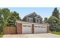 Image shows a two-story house with brick accents and a two car garage at 9229 Sugarstone Cir, Highlands Ranch, CO 80130