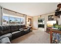 Comfortable living room featuring a large window, plush seating, and warm lighting at 3540 E 90Th Pl, Thornton, CO 80229