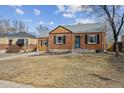Charming brick home with a well-manicured front yard and attached garage at 1610 Trenton St, Denver, CO 80220