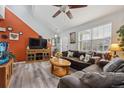 Open living room featuring hardwood floors, ceiling fan, and front door access at 11883 E 111Th Ave, Commerce City, CO 80640