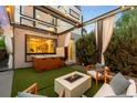 Backyard featuring a hot tub, fire pit, artificial turf, and string lights at 2242 W 34Th Ave, Denver, CO 80211