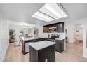 Modern kitchen boasts sleek black cabinetry, an island, stainless appliances and ample lighting at 6435 S Dayton St # 103, Englewood, CO 80111