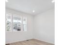 Bright bedroom featuring large windows and wood-look flooring for a modern aesthetic at 45928 Gentry Ave, Bennett, CO 80102