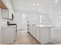 Modern kitchen with white cabinets, stainless steel appliances, and a functional center island at 45928 Gentry Ave, Bennett, CO 80102