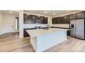 Modern kitchen boasts dark wood cabinetry, stainless appliances, white countertops and a center island at 4586 Windmill Dr, Brighton, CO 80601