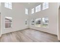 Bright living room boasts soaring ceilings and an abundance of natural light through large picture windows at 4586 Windmill Dr, Brighton, CO 80601