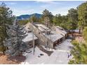 A luxurious home nestled in a snow covered landscape at 3028 Olympia Cir, Evergreen, CO 80439