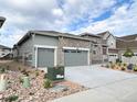 Charming home featuring a stone facade, an attached two car garage and xeriscaping at 3966 Doubletrack Ln, Castle Rock, CO 80108
