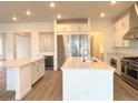 Bright, open kitchen with stainless steel appliances, double islands and white cabinets at 3966 Doubletrack Ln, Castle Rock, CO 80108