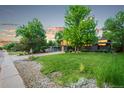 Charming home featuring a lush green lawn, mature trees, and a welcoming modern exterior at 1440 S Dahlia St, Denver, CO 80222