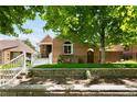 Brick home with tiered stone retaining wall, yard, and entry steps at 3036 Birch St, Denver, CO 80207